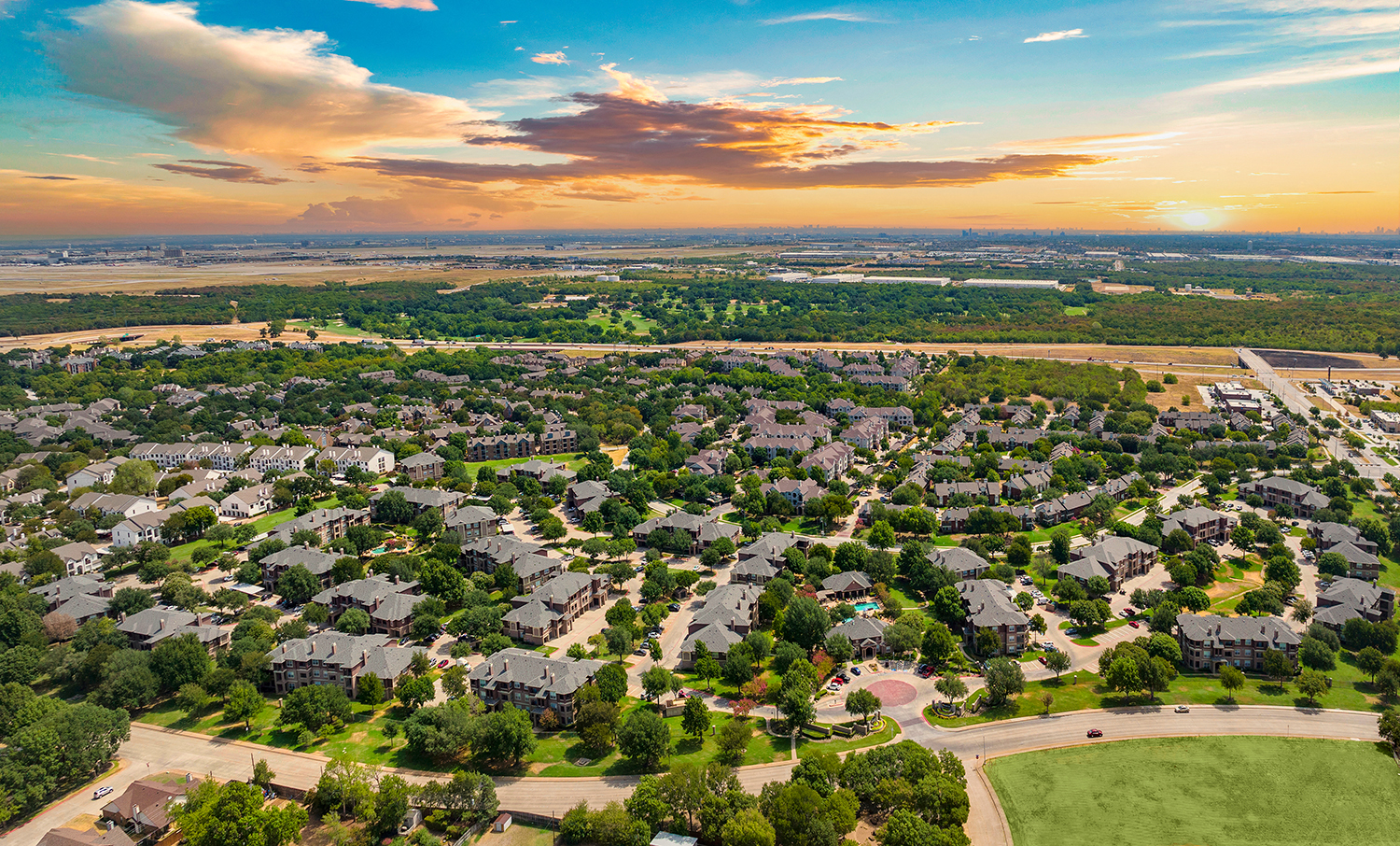 an aerial view of a suburb of a city at sunset