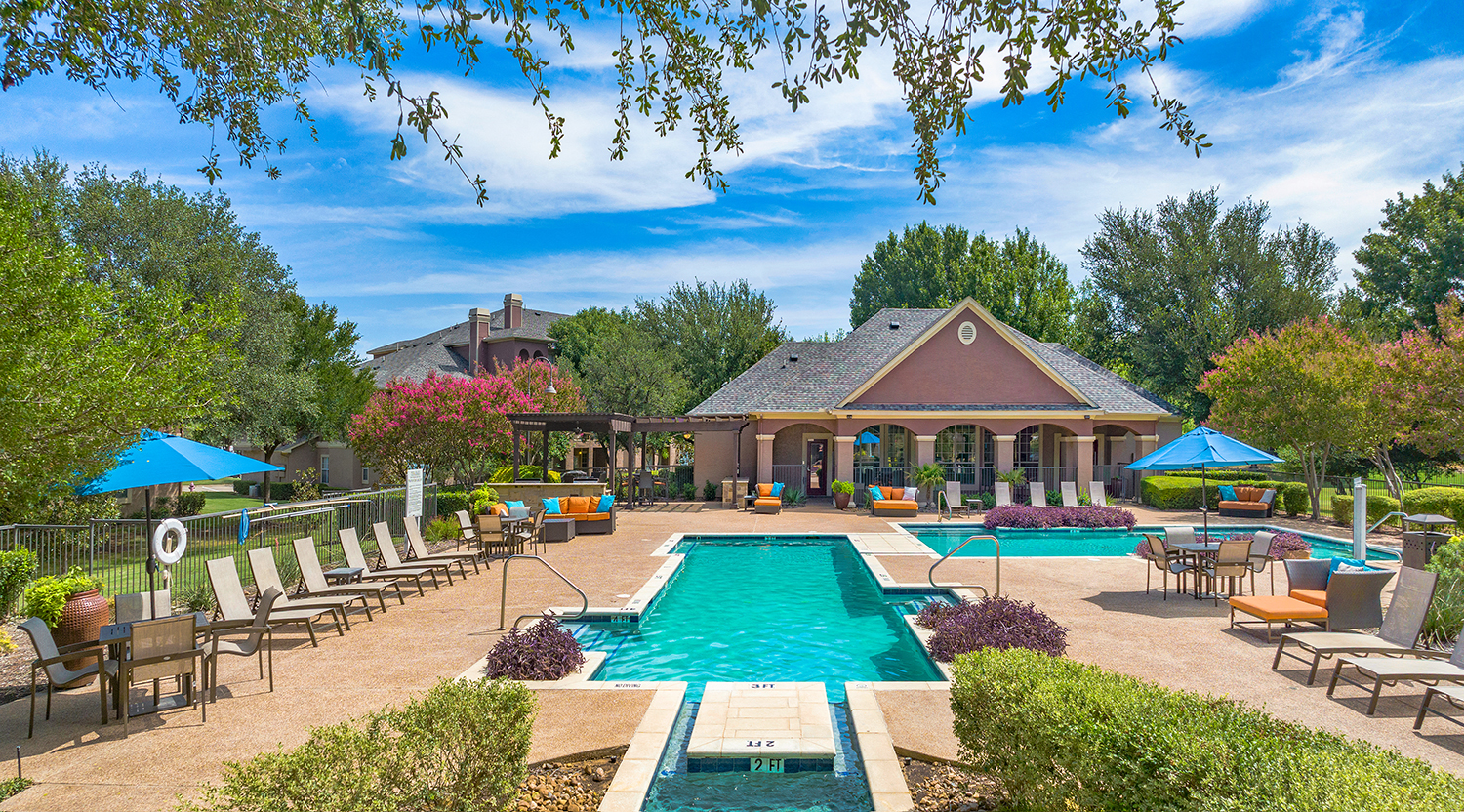 a swimming pool with lounge chairs and a house with a pool