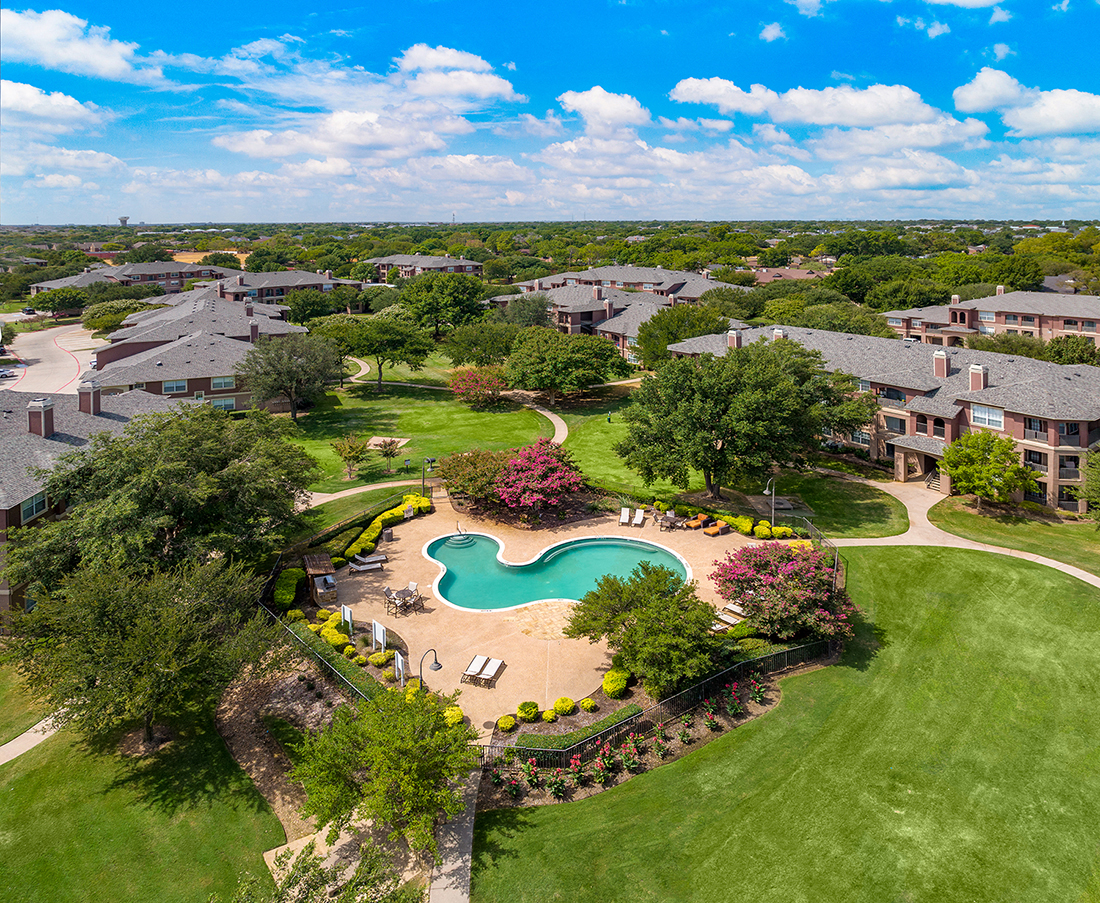 an aerial view of a swimming pool in a community with houses
