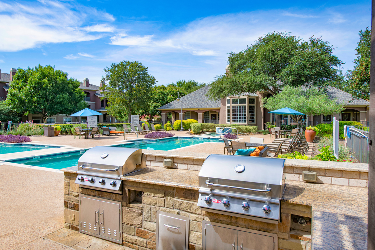 a backyard with a pool and barbecue grill    and a house