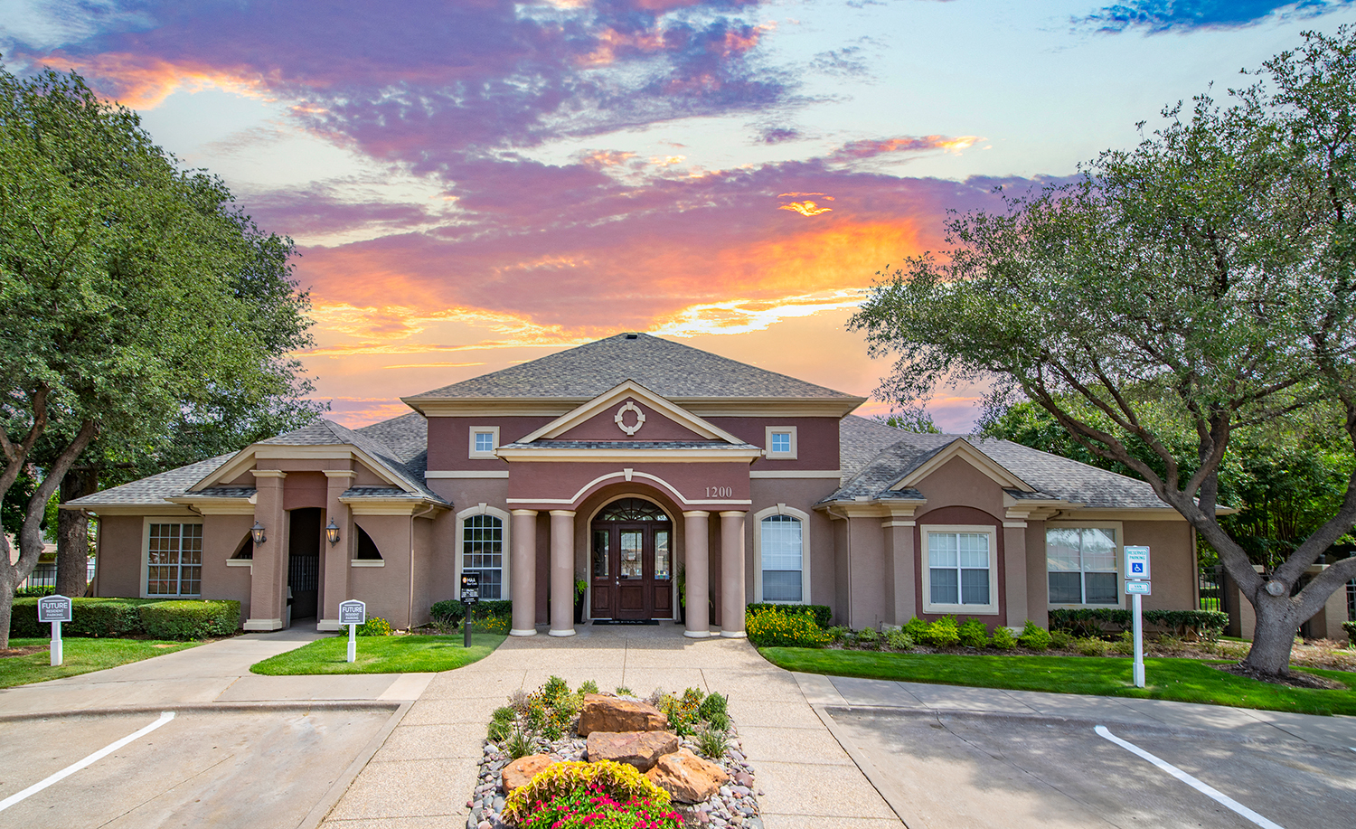 the front of a house with a sunset in the background