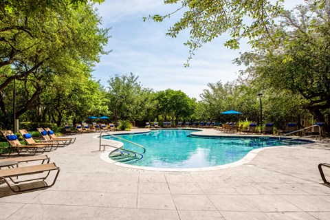 a swimming pool with chairs and umbrellas at the resort