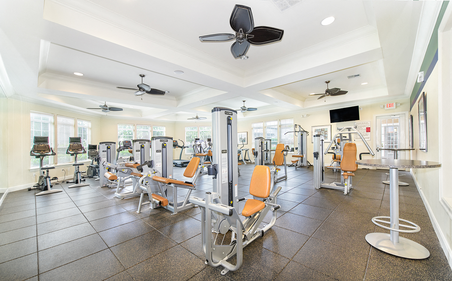 a gym with cardio equipment and weights on the floor