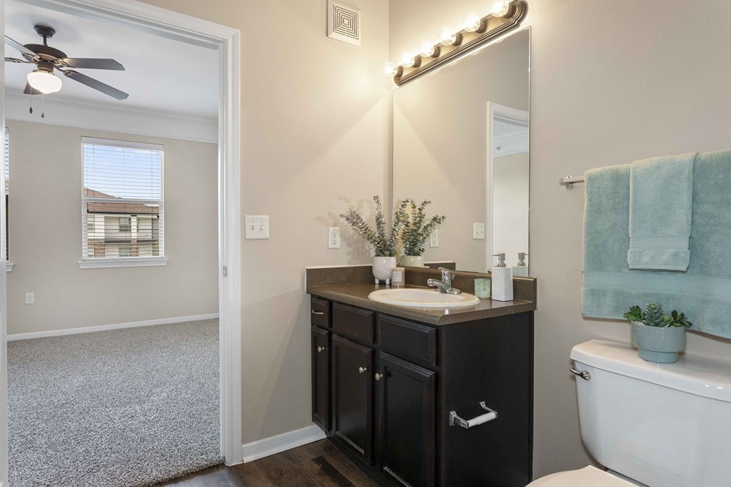 A bathroom with a white tub, a sink, and a mirror.