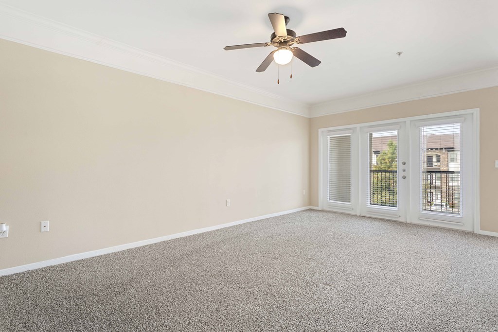 A room with a ceiling fan and carpeted floor.
