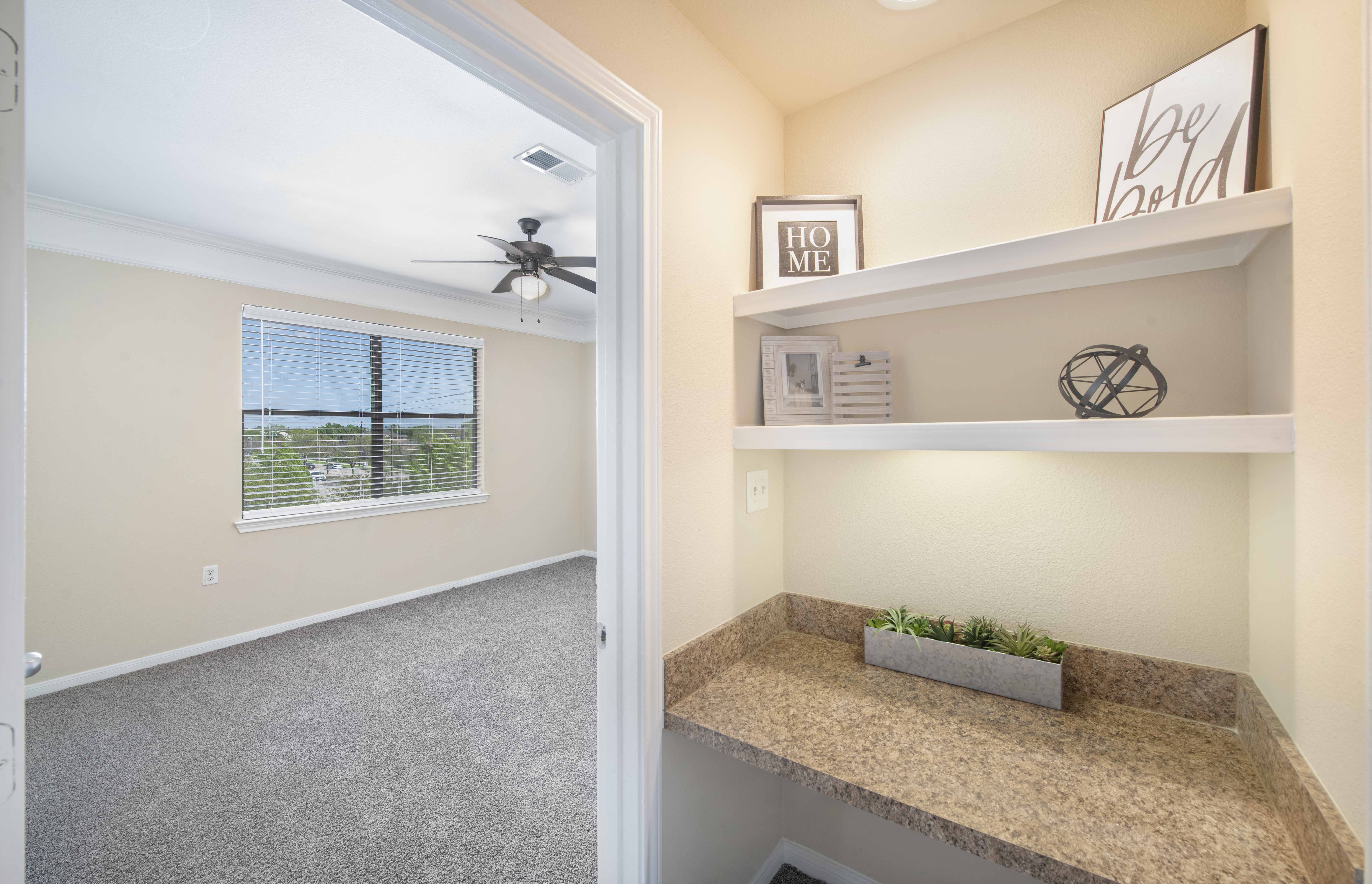 a room with a counter and a window and a ceiling fan