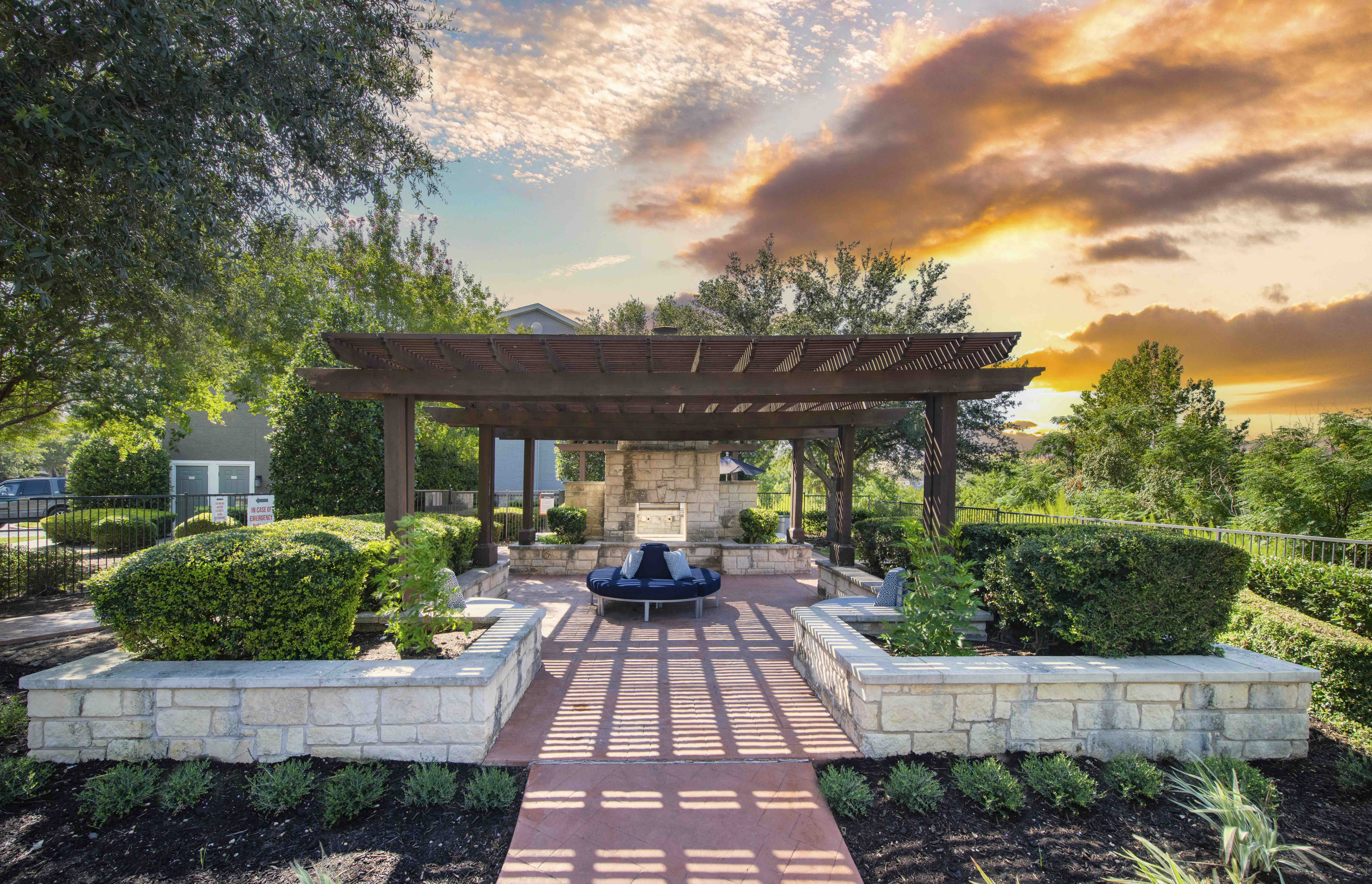 a patio with a pavilion and a fire pit at sunset