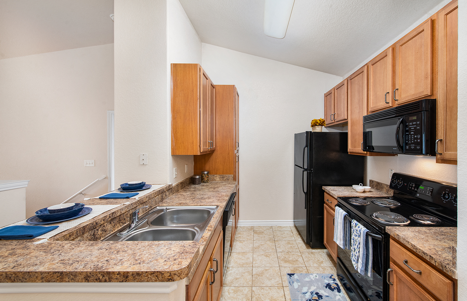 a kitchen with black appliances and granite counter tops