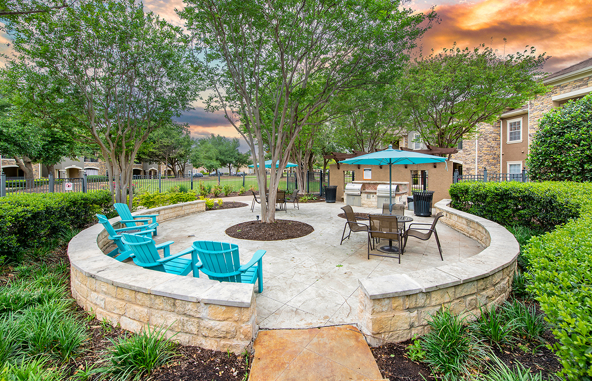 a patio with a table and chairs and a fire pit