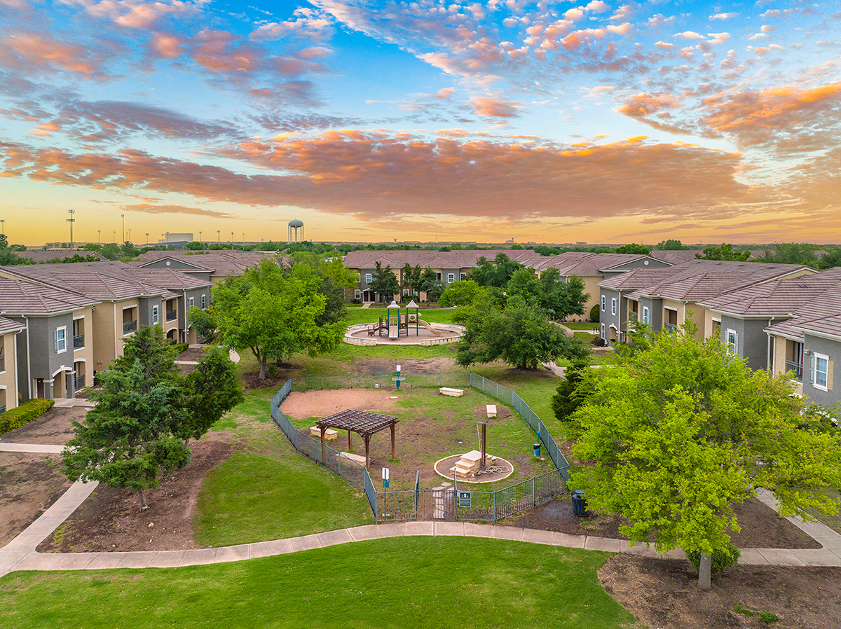 an aerial view of a park with houses and a fountain