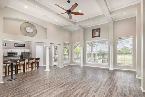 A spacious room with a ceiling fan and wooden flooring.