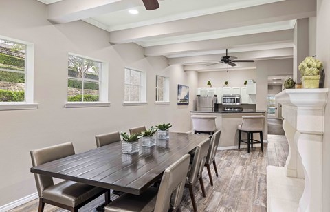 A modern dining room with a large table and chairs.