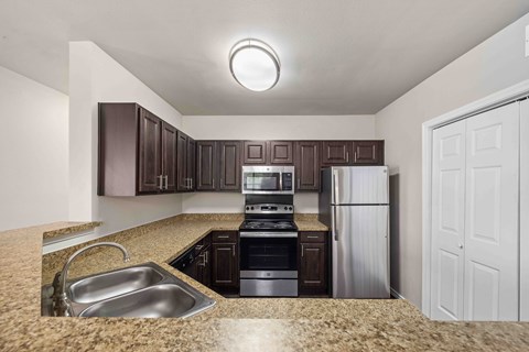 A kitchen with brown cabinets and a white refrigerator.