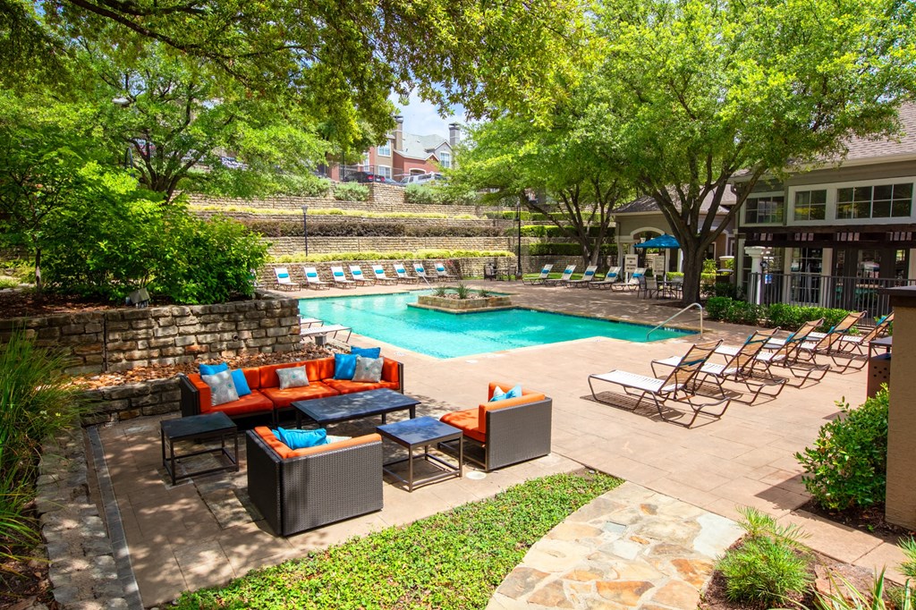 a swimming pool with lounge chairs and a resort style pool