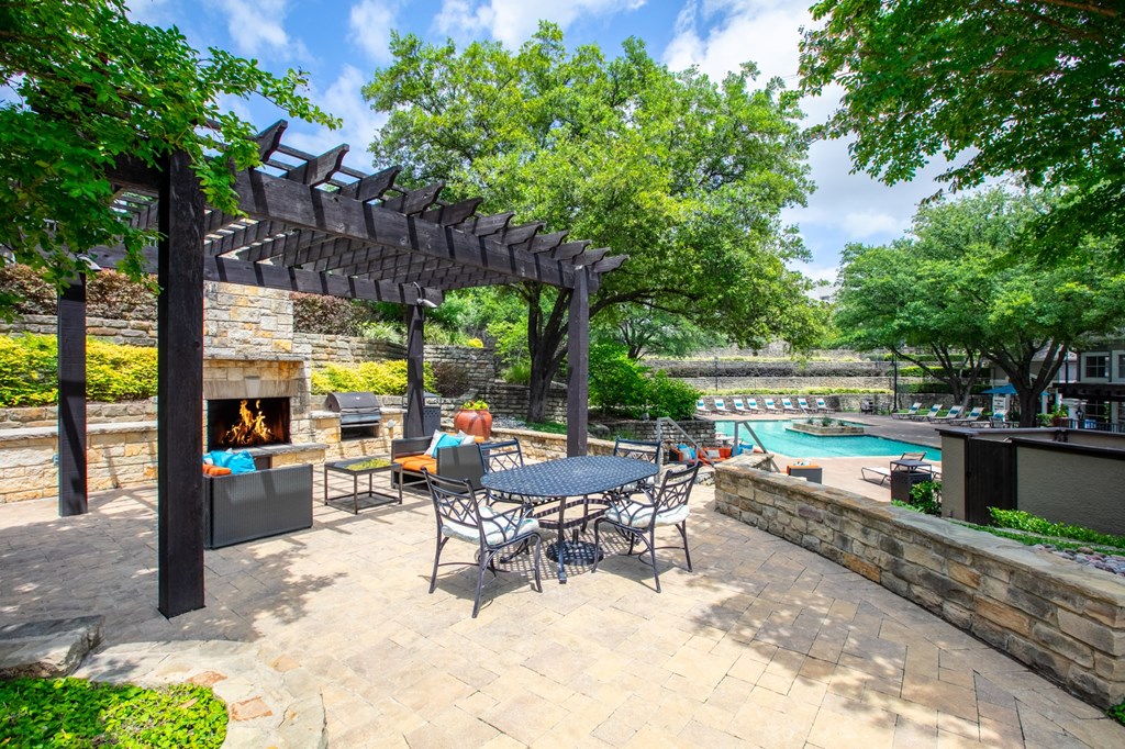 a patio with a table and chairs next to a swimming pool