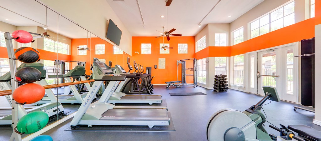 a gym with weights and other exercise equipment and windows
