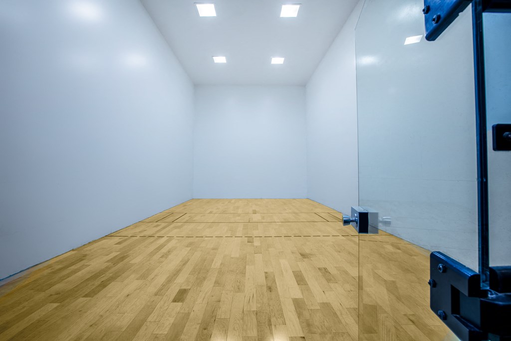 a tennis court in a white room with a wood floor