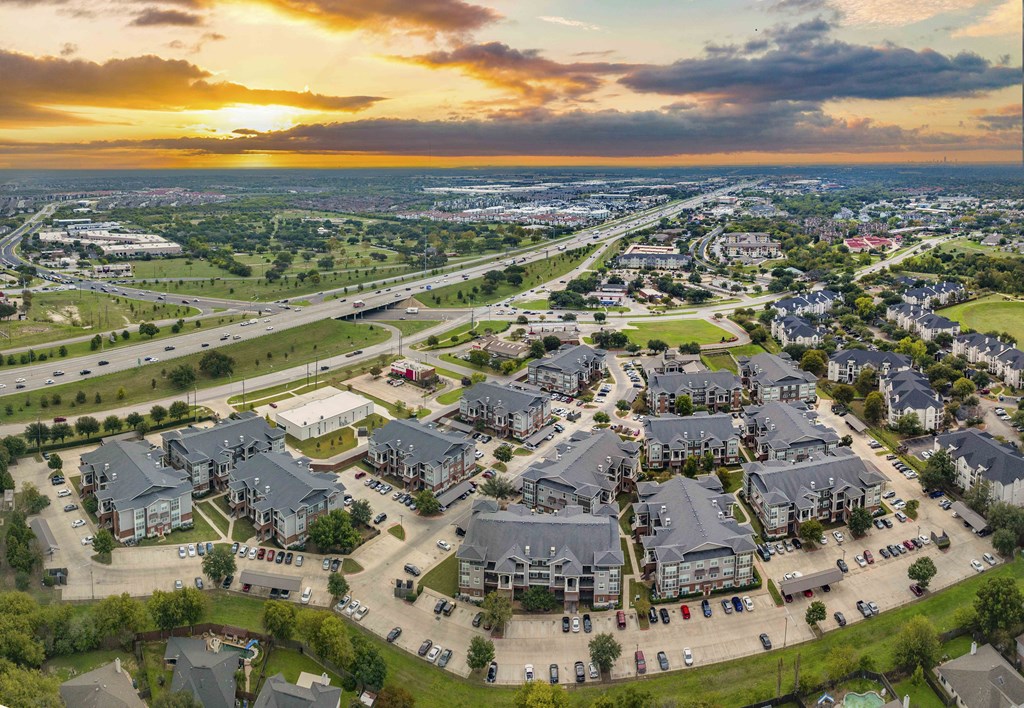 an aerial view of a suburb of a city with cars on the street