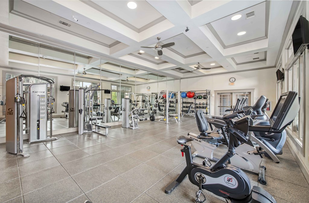 a gym with weights and cardio machines and a coffered ceiling