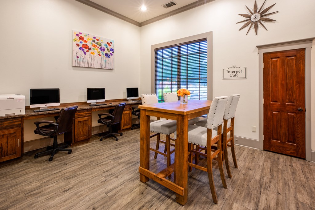 the retreat at home office with a table and chairs and two computers