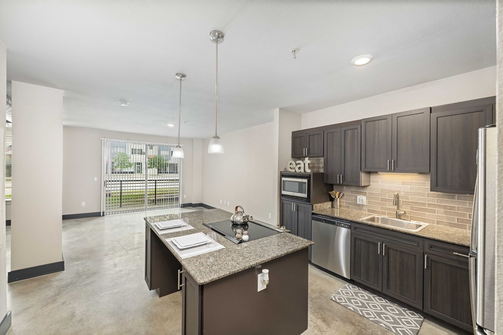 a kitchen with dark cabinets and a large island in the middle