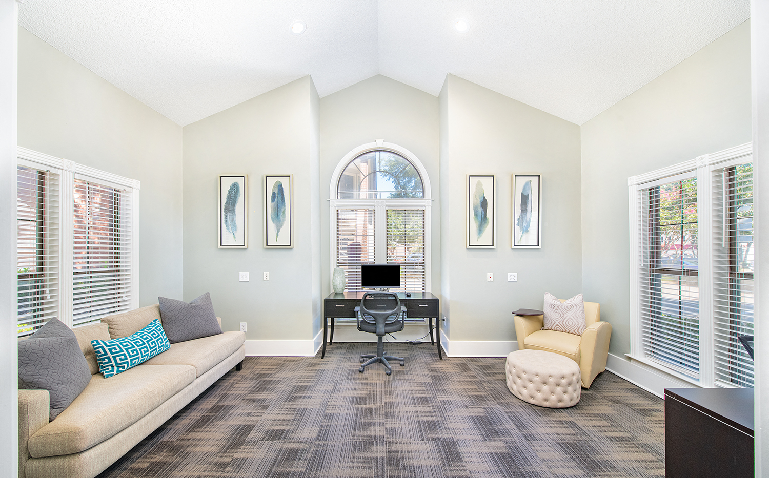 a living room with a couch and a chair and a desk