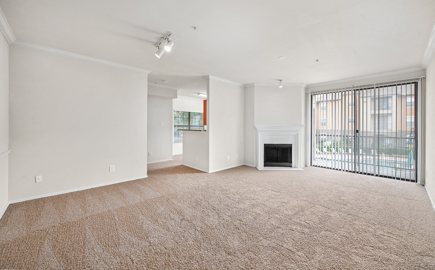 an empty living room with a fireplace and a window