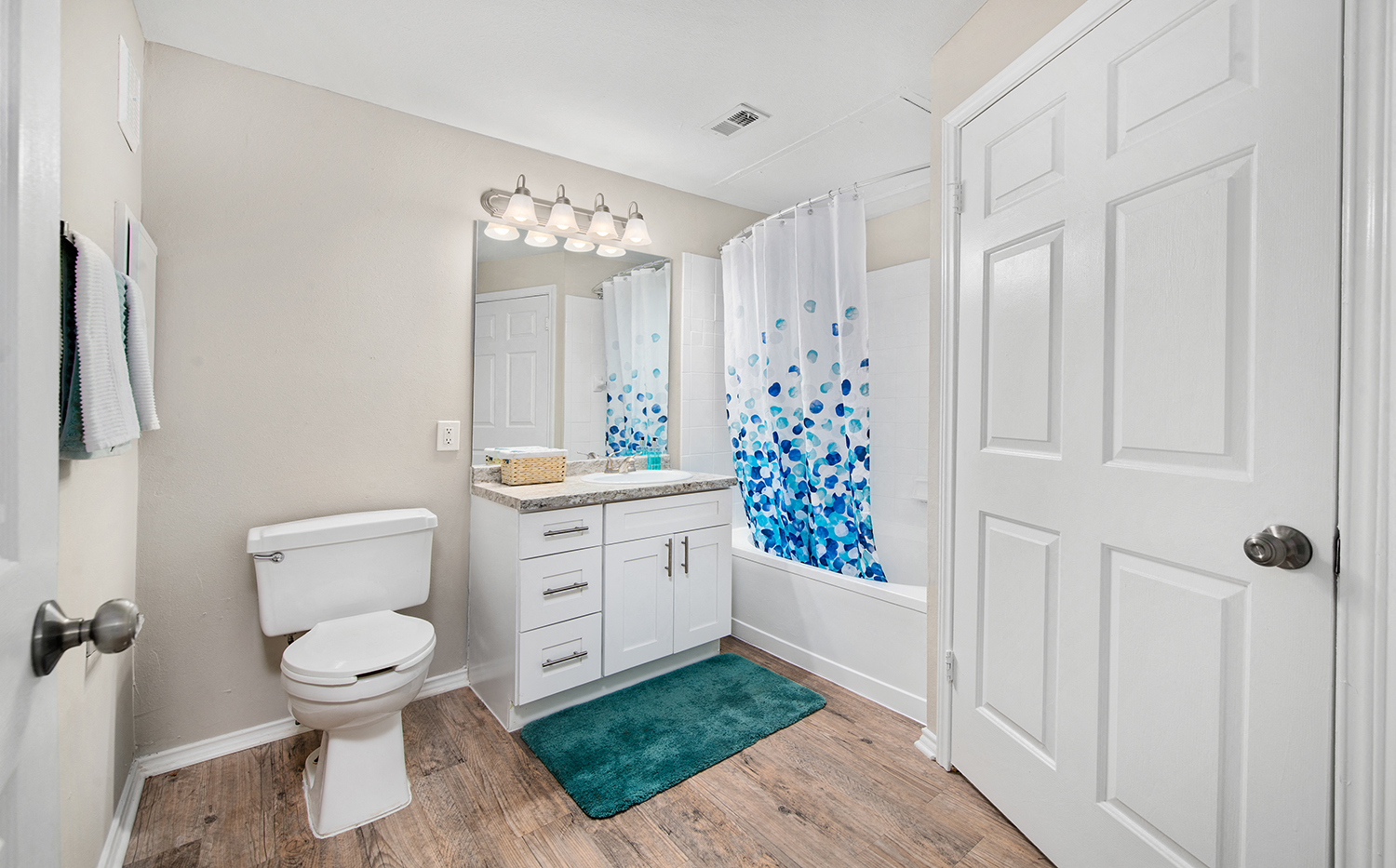 a white bathroom with a toilet and a shower