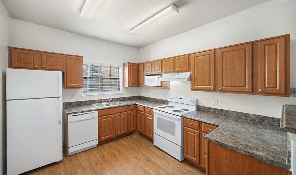 a kitchen with white appliances and wooden cabinets