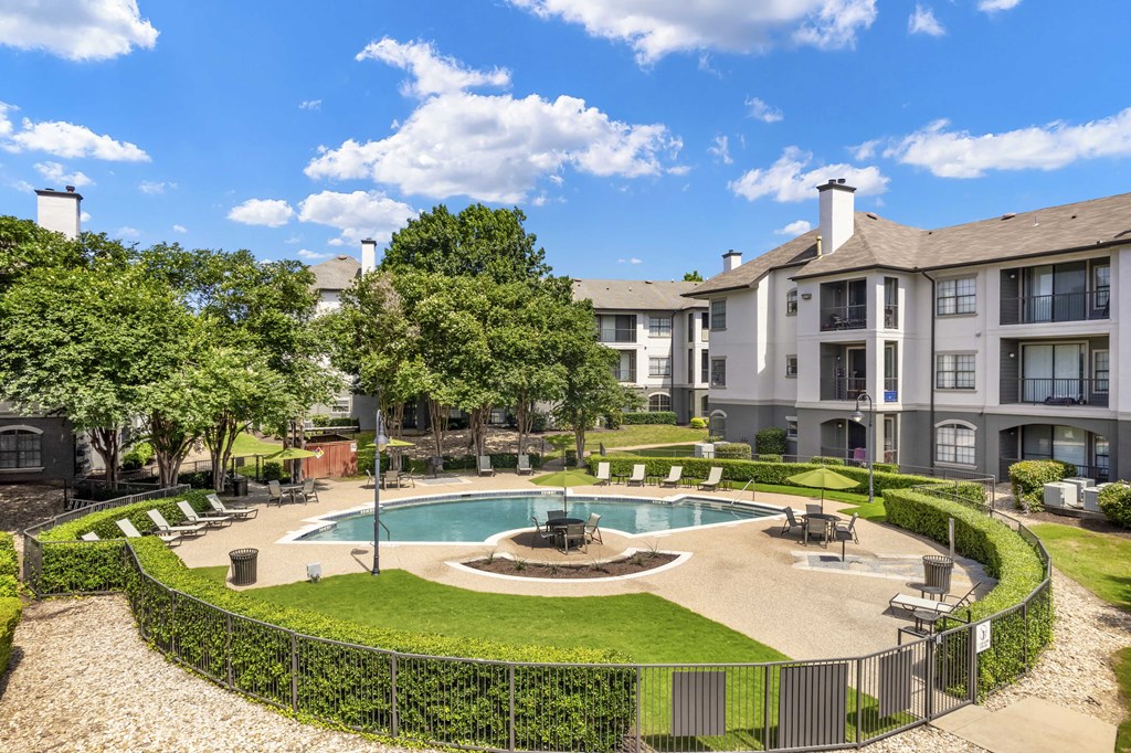 a courtyard with a fountain and a pool with an apartment building in the background