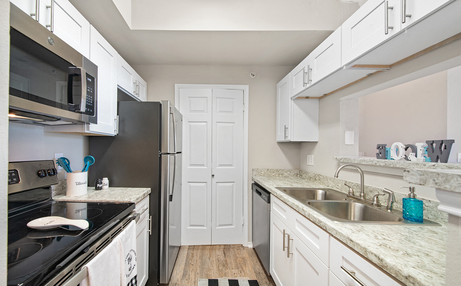 a kitchen with stainless steel appliances and white cabinets