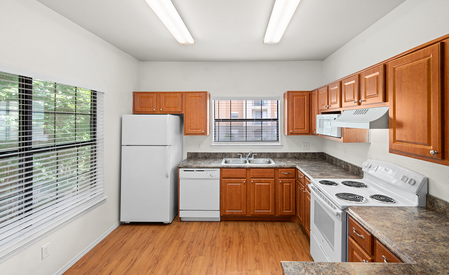 a kitchen with white appliances and wooden cabinets