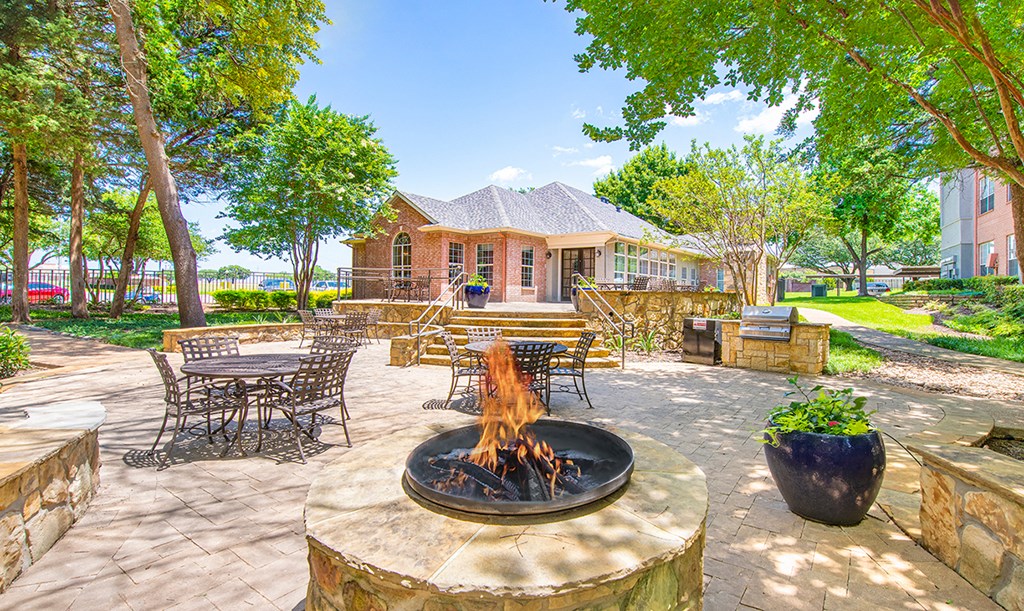the back patio with a fire pit and tables and chairs