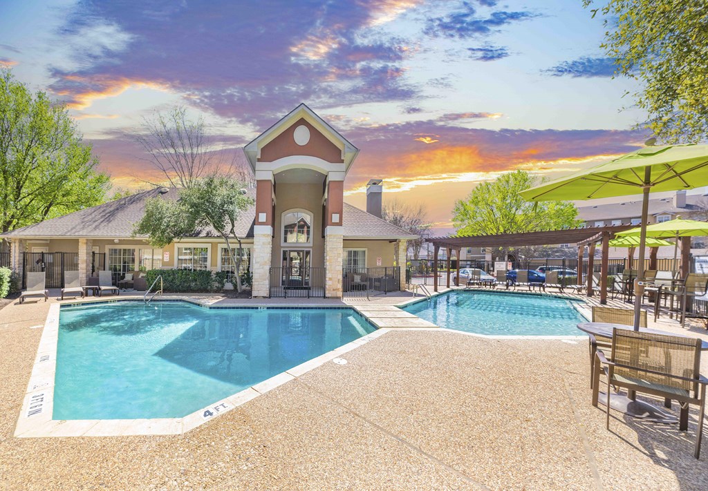 A large outdoor swimming pool with a building in the background.