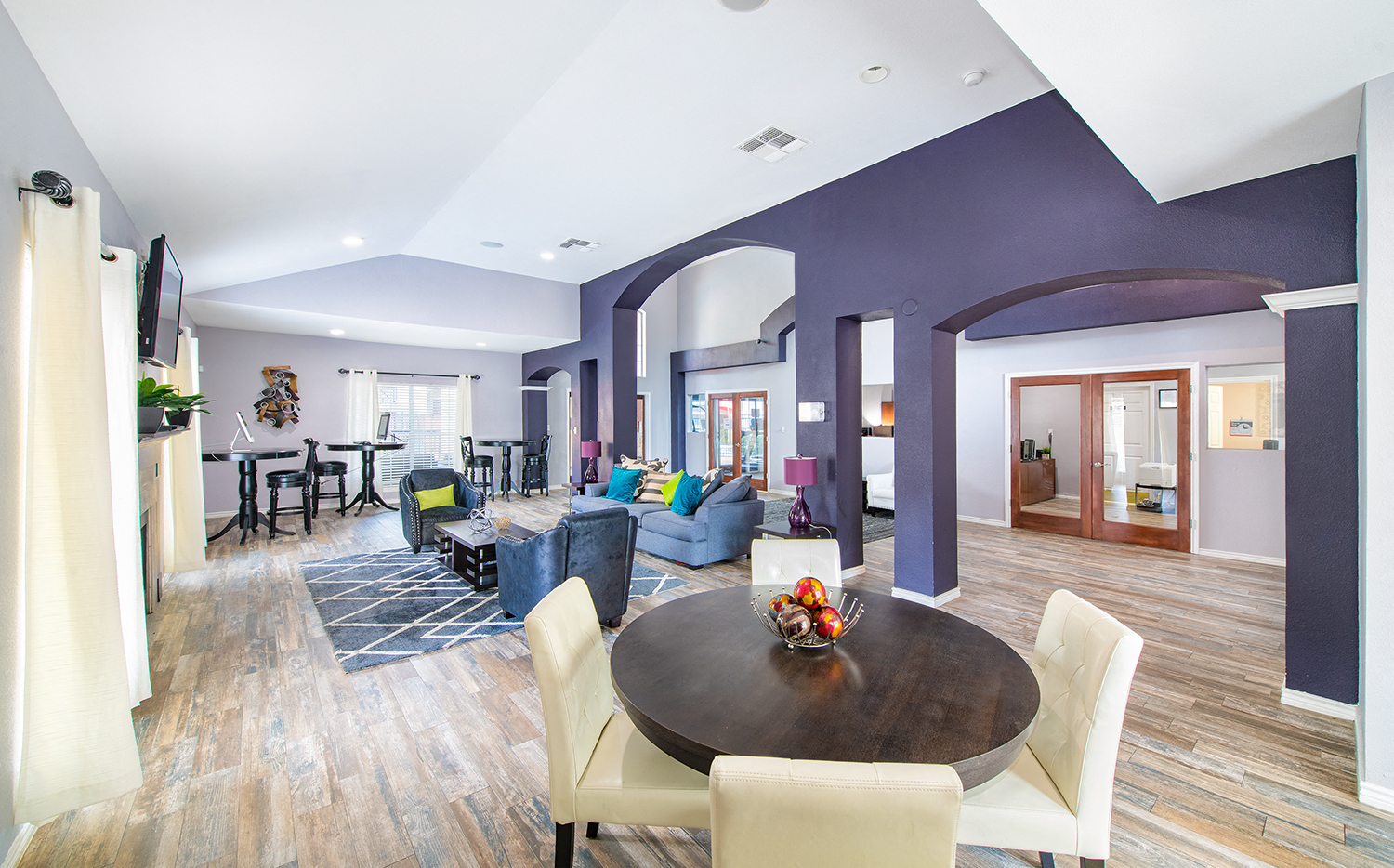 a living room and dining room with purple walls and a table