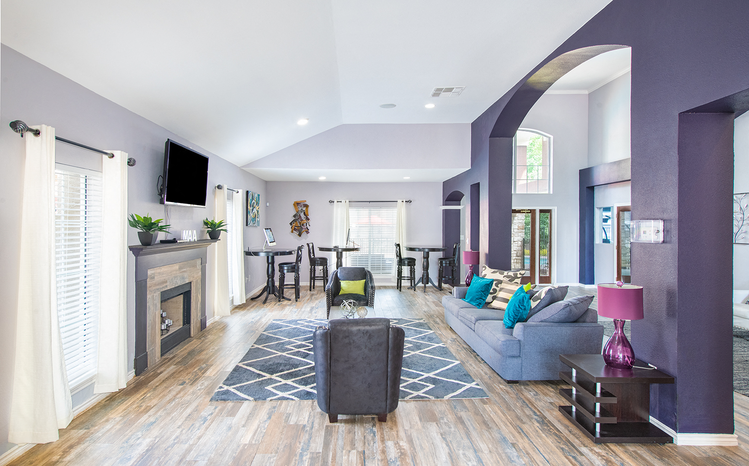 a living room with purple walls and a fireplace