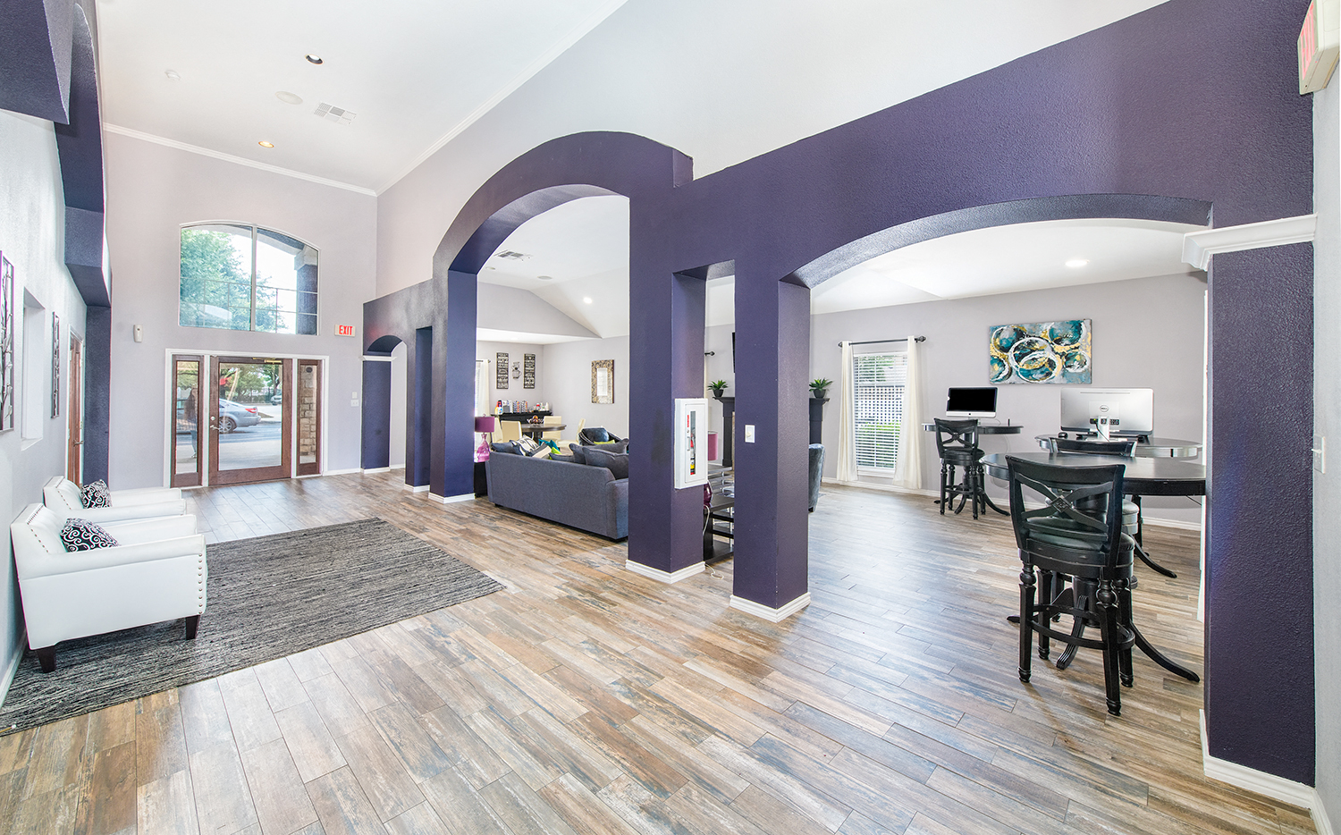a living room and dining room with purple walls and wood floors