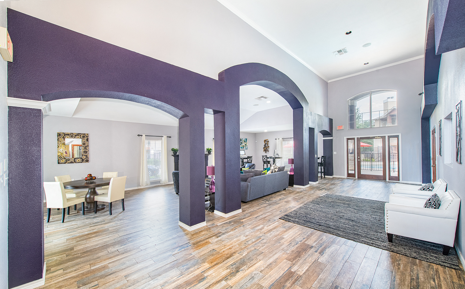 a large living room with purple walls and a hardwood floor