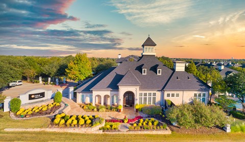 an aerial view of a house with flowers on the front yard