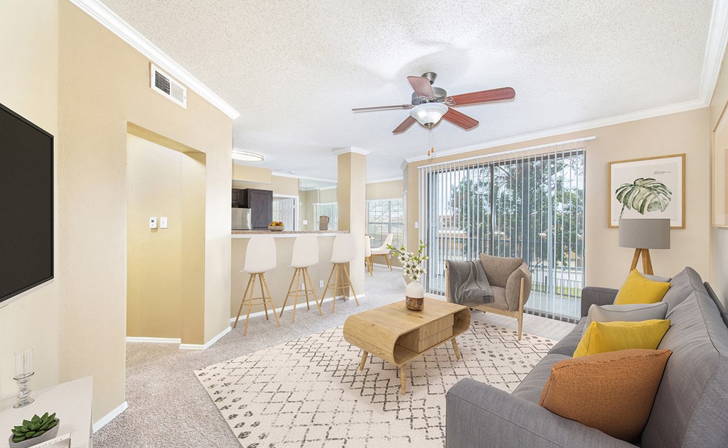 the living room and dining room with a ceiling fan and a large window