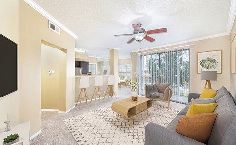 the living room and dining room with a ceiling fan and a large window