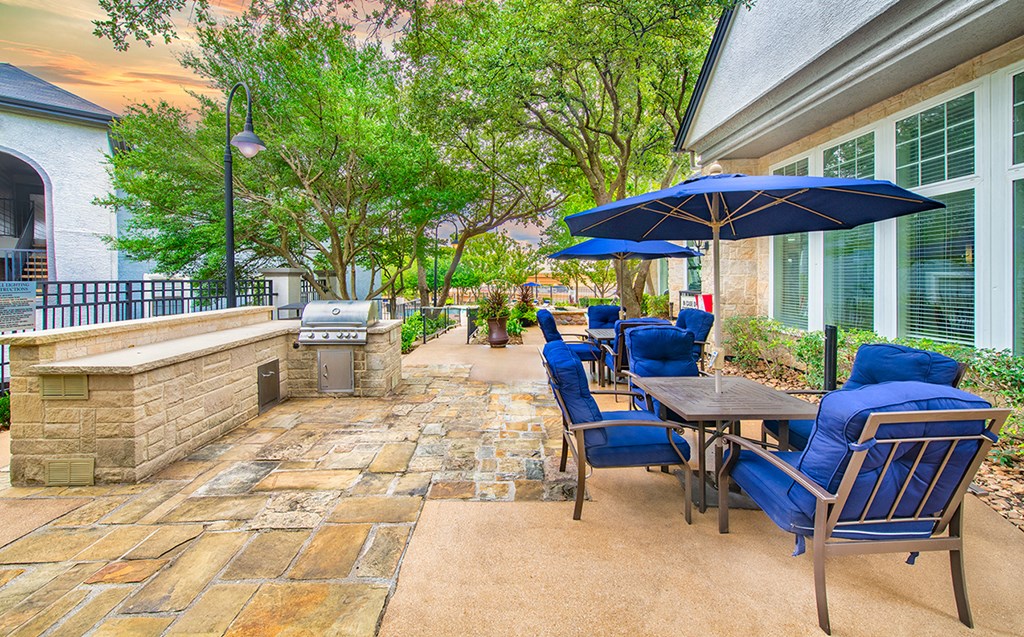 a patio with a table and chairs and umbrellas