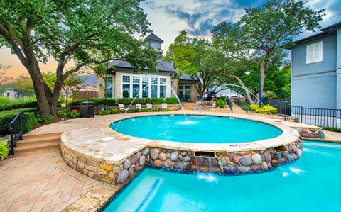 a swimming pool with a fountain in front of a house