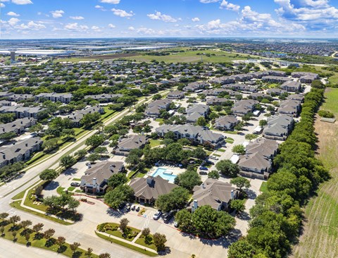 A bird's eye view of a residential neighborhood with houses and a swimming pool.