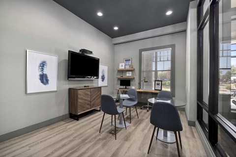 A room with a television, chairs, and a cabinet.