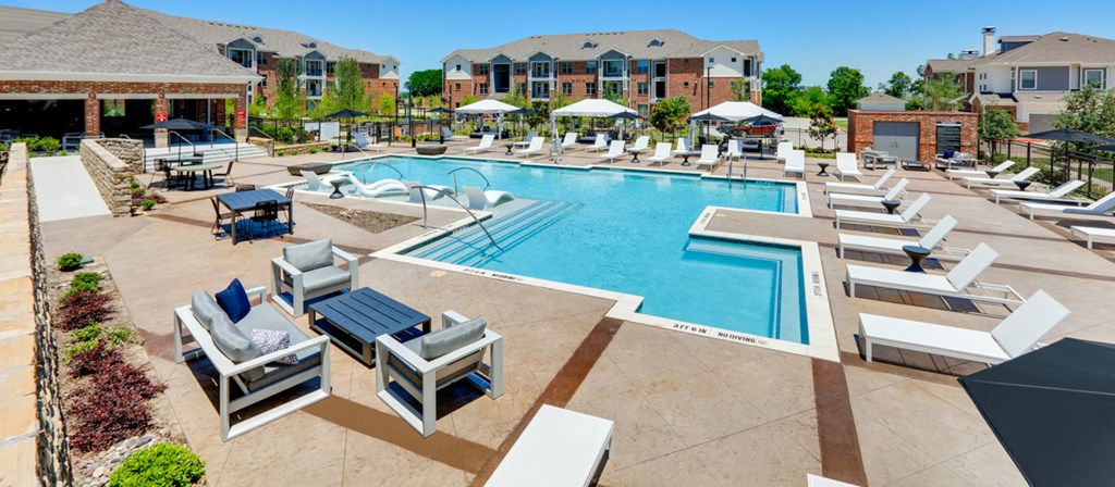 a swimming pool with lounge chairs and umbrellas at the resort on a sunny