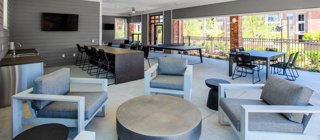 a lounge area with tables and chairs and a television