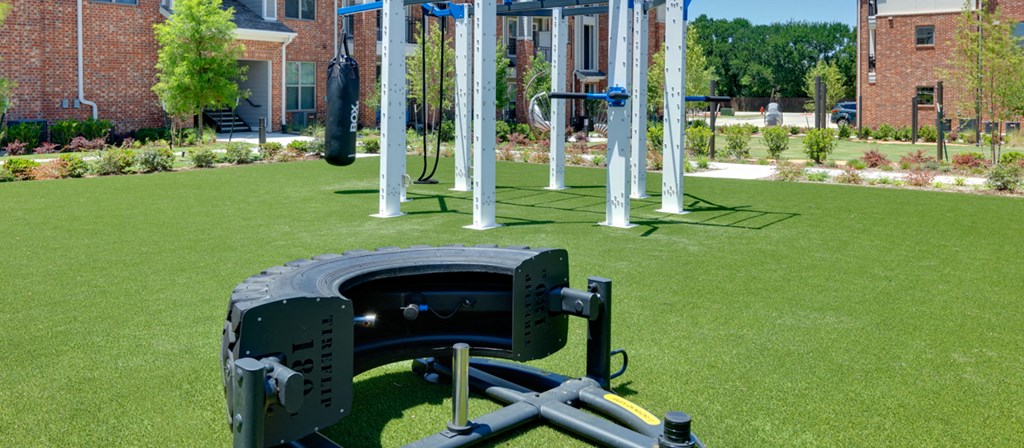 a swing set on the grass in front of playground equipment