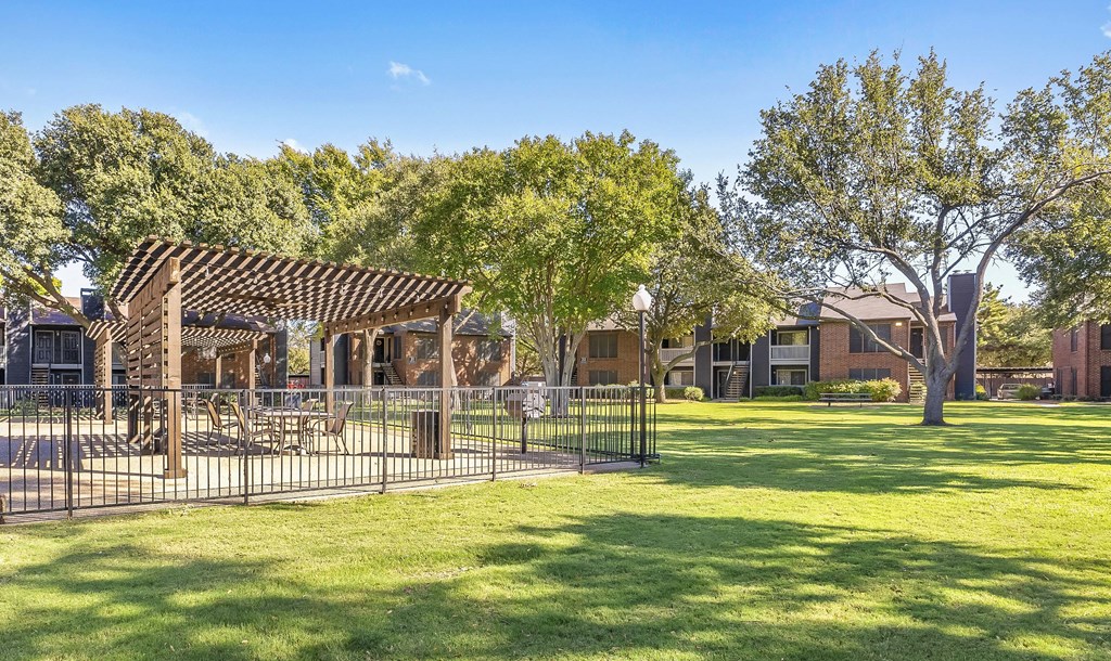 A park with a wooden structure and a fence.
