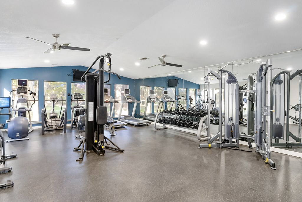 A spacious gym with a variety of equipment including treadmills, weights, and exercise machines.